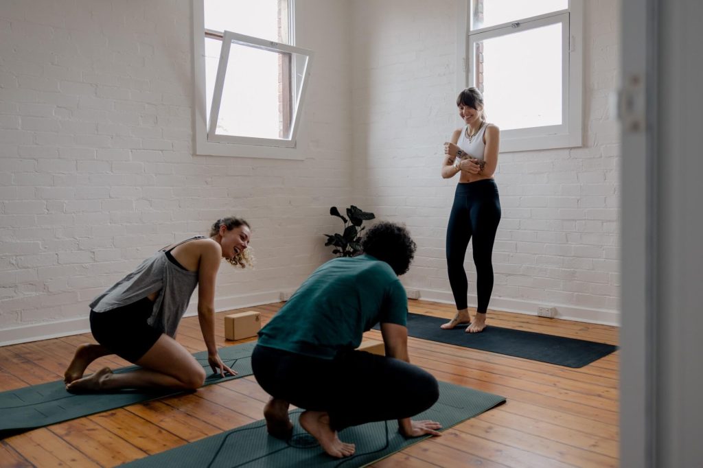 3 people of mixed gender enjoying yoga class
