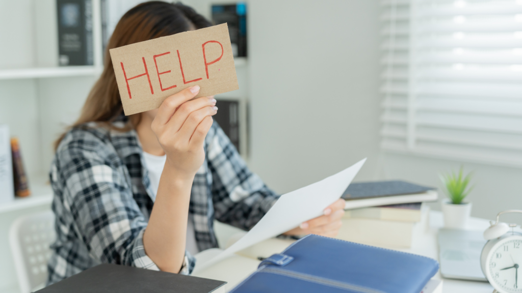 A young woman holding a help sign. Breathwork is the answer to conquering exam stress