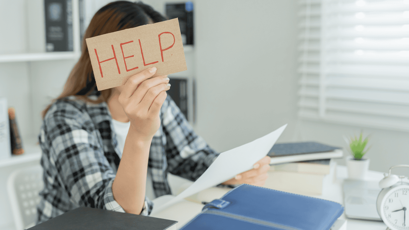 A young woman holding a help sign. Breathwork is the answer to conquering exam stress